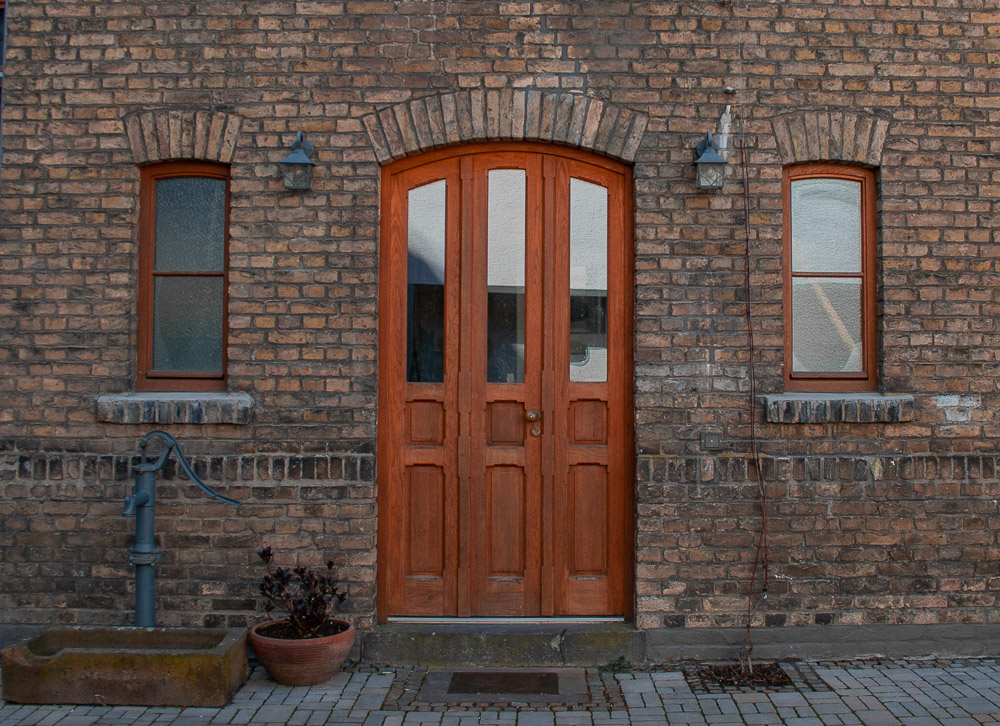 Eingangsbereich mit alter Holztüre und Steinfassade