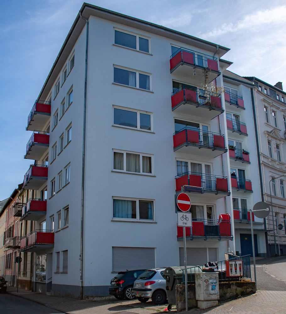Mehrfamilien-Eckhaus mit roten Balkonen